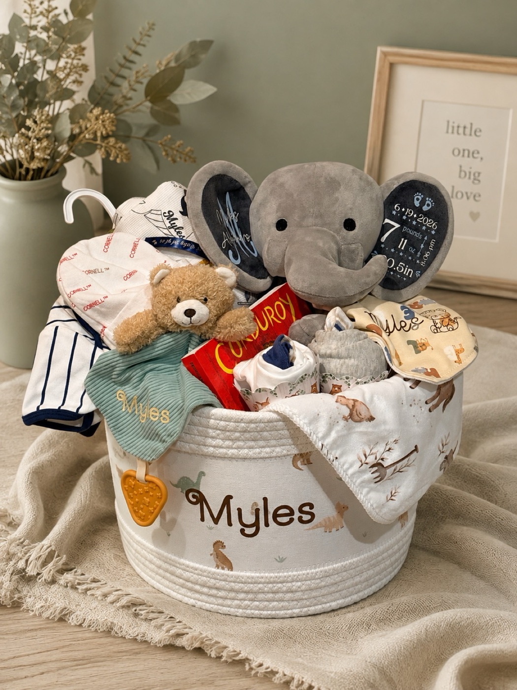 A new baby basket in a personalised rope basket with a plush elephant, bear and bodysuits