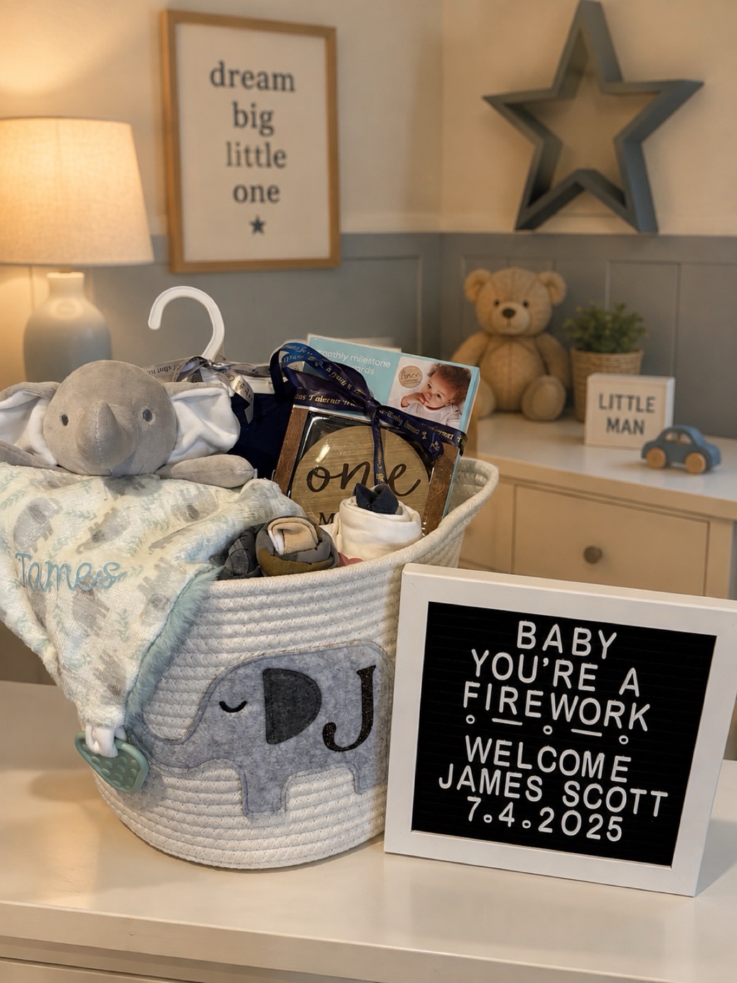 A blue and grey new baby basket beside a letterboard announcing the arrival